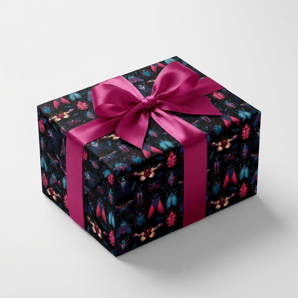 Rectangular gift wrapped in black wrapping paper with colorful beetle pattern and bright pink ribbon.