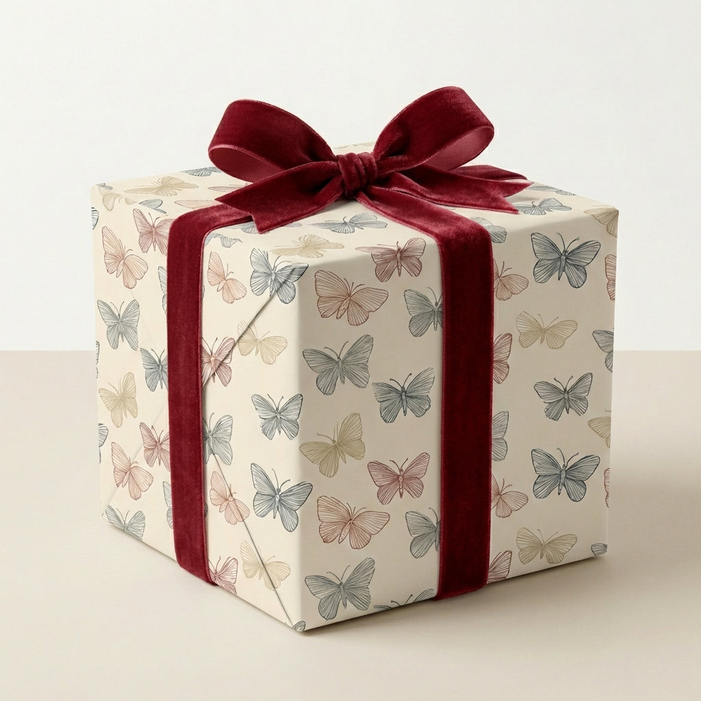 Elegant gift box wrapped in butterfly wrapping paper with a deep red velvet ribbon.