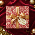 Elegant Christmas gift wrapped in red floral paper with a gold ribbon and "Happy Holidays" tag.