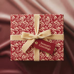 Elegant red floral wrapping paper with gold ribbon and "Season's Greetings" tag.