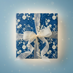 Square gift wrapped in elegant floral wrapping paper with a sheer white ribbon.