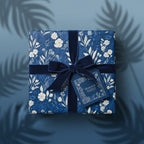 Elegant navy floral wrapping paper with velvet ribbon and gift tag.
