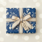 Square gift wrapped in blue floral wrapping paper with a striped bow.