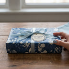 Navy floral wrapping paper with light blue ribbon and tag.