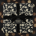 Elegant black floral wrapping paper with velvet bow for luxurious gift presentation.