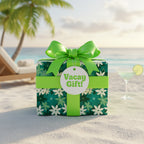Vacation gift box wrapped in floral wrapping paper with bright green ribbon & a tag that reads "Vacay Gift!" on a tropical beach.