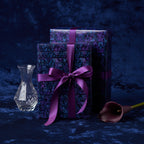 Elegant gift wrap: Navy blue wrapping paper with geometric pattern and purple satin ribbon.