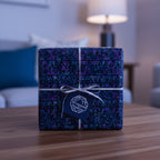 Geometric wrapping paper in blue and purple, tied with a silver ribbon, perfect for a modern gift.