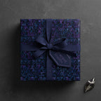 Modern birthday wrapping paper with dark geometric design, navy ribbon and gift tag.