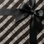 Modern gift wrap with black and white geometric pattern and elegant black ribbon bow.