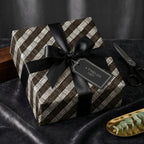 Elegant woven pattern wrapping paper with a black satin ribbon and gift tag for a timeless present.