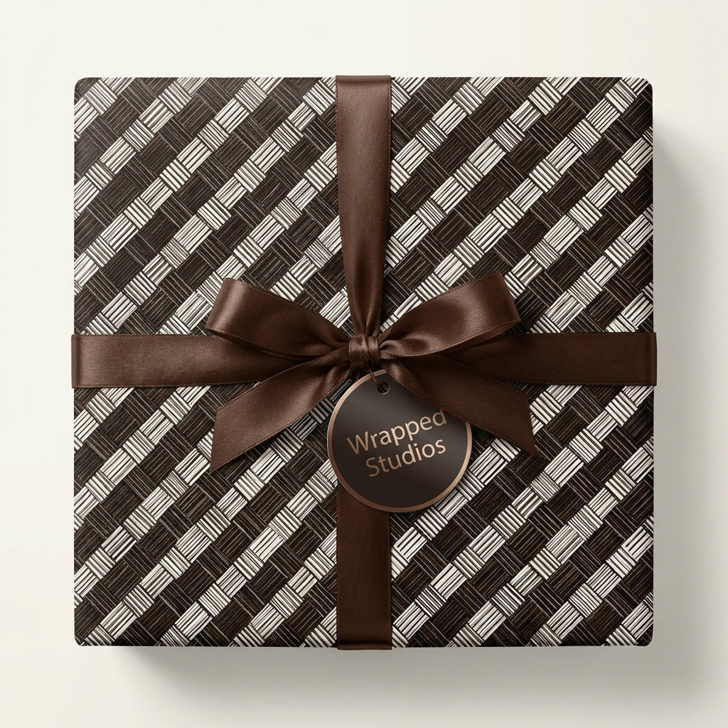 Elegant gift box wrapped in modern geometric patterned paper with a chocolate brown satin ribbon and bow.