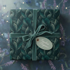 Elegant gift wrapped in luxury botanical wrapping paper with a velvet teal ribbon and tag.