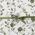 Elegant floral wrapping paper with olive-green botanical pattern and ribbon bow.