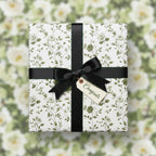 Elegant floral wrapping paper with black ribbon & "Congrats" tag, ideal for graduation or wedding gifts.