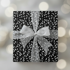 Elegant gift with black floral wrapping paper and sheer silver ribbon bow.