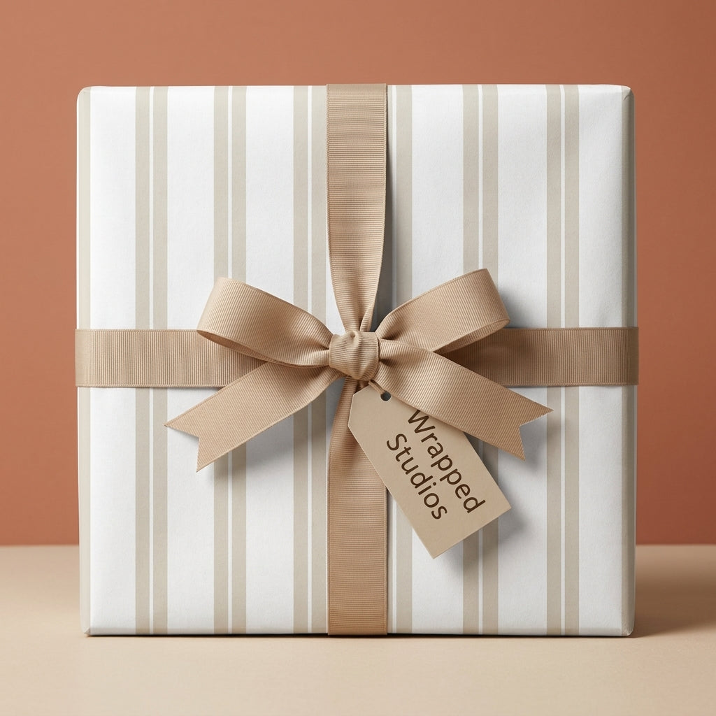 Minimalist striped wrapping paper in beige and white with a matching bow by Wrapped Studios.