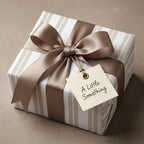 Elegant striped wrapping paper in beige and white with a luxury satin ribbon, from Wrapped Studios.
