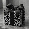 Modern black and white circle pattern luxury wrapping paper with a satin bow by Wrapped Studios.
