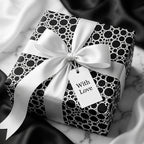 Luxury black and white polka dot wrapping paper with a white satin bow on a gift box by Wrapped Studios.
