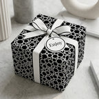 Modern black and white polka dot wrapping paper on a luxury gift box with ribbon by Wrapped Studios.