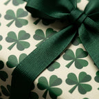 St. Patrick's Day shamrock wrapping paper with a dark green ribbon bow by Wrapped Studios.