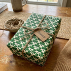 St. Patrick's Day shamrock wrapping paper with rustic twine bow and Cheers tag by Wrapped Studios.