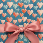 Heart-patterned wrapping paper with a pink bow, perfect for Valentine's Day gifts.