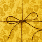 Mustard yellow floral wrapping paper with a rustic twine bow.