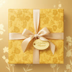 Golden floral wrapping paper with satin ribbon and "A Golden Moment" tag.