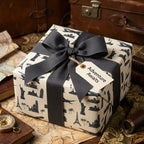 Vintage travel wrapping paper with world landmarks, grey bow, and gift tag by Wrapped Studios.