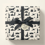 Minimalist travel wrapping paper with black world landmarks and a chic ribbon bow by Wrapped Studios.