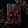Luxury dark floral Christmas wrapping paper with a burgundy satin ribbon by Wrapped Studios.