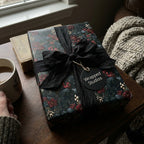 Moody floral Christmas wrapping paper with a black silk ribbon and Wrapped Studios gift tag.