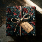 Dark floral wrapping paper with twine bow and Adventure Awaits tag by Wrapped Studios.