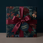 Luxury dark moody floral wrapping paper with a burgundy satin ribbon and tag by Wrapped Studios.