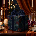 Luxury dark floral wrapping paper with navy velvet bow on elegant holiday table by Wrapped Studios.