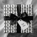 Luxury black and white modern wrapping paper with a black ribbon bow and gift tag by Wrapped Studios.
