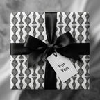 Luxury black and white modern wrapping paper with a black ribbon bow and gift tag by Wrapped Studios.