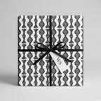 Modern black and white wavy geometric wrapping paper on a gift box by Wrapped Studios.