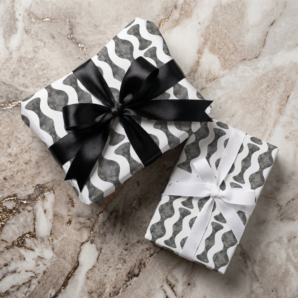 Modern black and white wavy wrapping paper on gift boxes with ribbons by Wrapped Studios.
