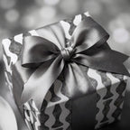 Modern black and white wavy wrapping paper with a luxury grey satin ribbon bow by Wrapped Studios.