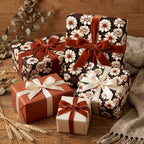 Vintage floral wrapping paper and luxury gift wrap with velvet bows on a rustic table by Wrapped Studios.