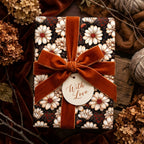 Vintage floral wrapping paper with white daisies, a rust velvet bow, and a "With Love" tag by Wrapped Studios.