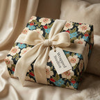 Luxury black floral wrapping paper with cream velvet bow on a gift box by Wrapped Studios.