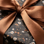Moody vintage floral wrapping paper with white daisies and a copper satin ribbon bow by Wrapped Studios.