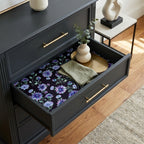 Moody purple floral wrapping paper used as drawer liner in a black dresser by Wrapped Studios.
