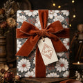 Vintage floral wrapping paper with a rust velvet bow and gift tag by Wrapped Studios.