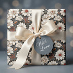 Elegant floral wrapping paper with cream satin bow and gift tag by Wrapped Studios.