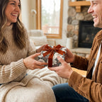 Couple exchanging a gift in vintage floral wrapping paper with a rust velvet ribbon, by Wrapped Studios.